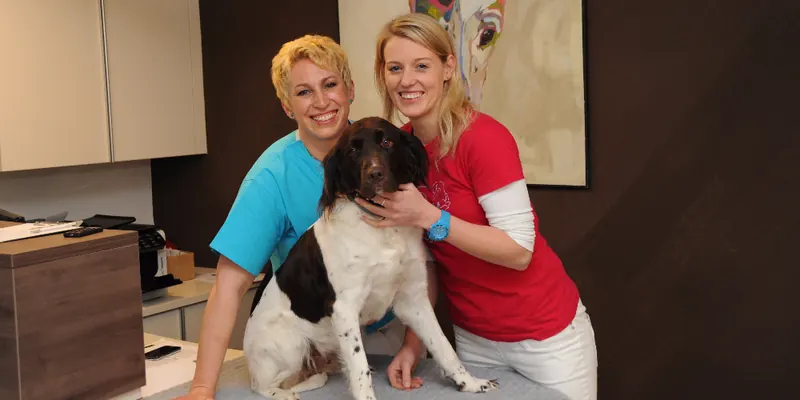 Dr. Elke Zimmermann und ihre Assistentin Barbara Oberlerchner mit einem Hund in der Ordination